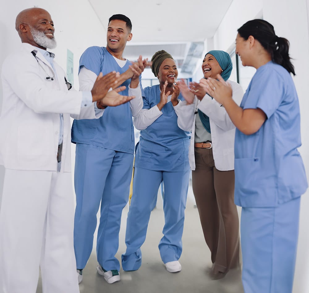 Happy doctors and nurses clapping hands in commitment, trust and support of medical goals