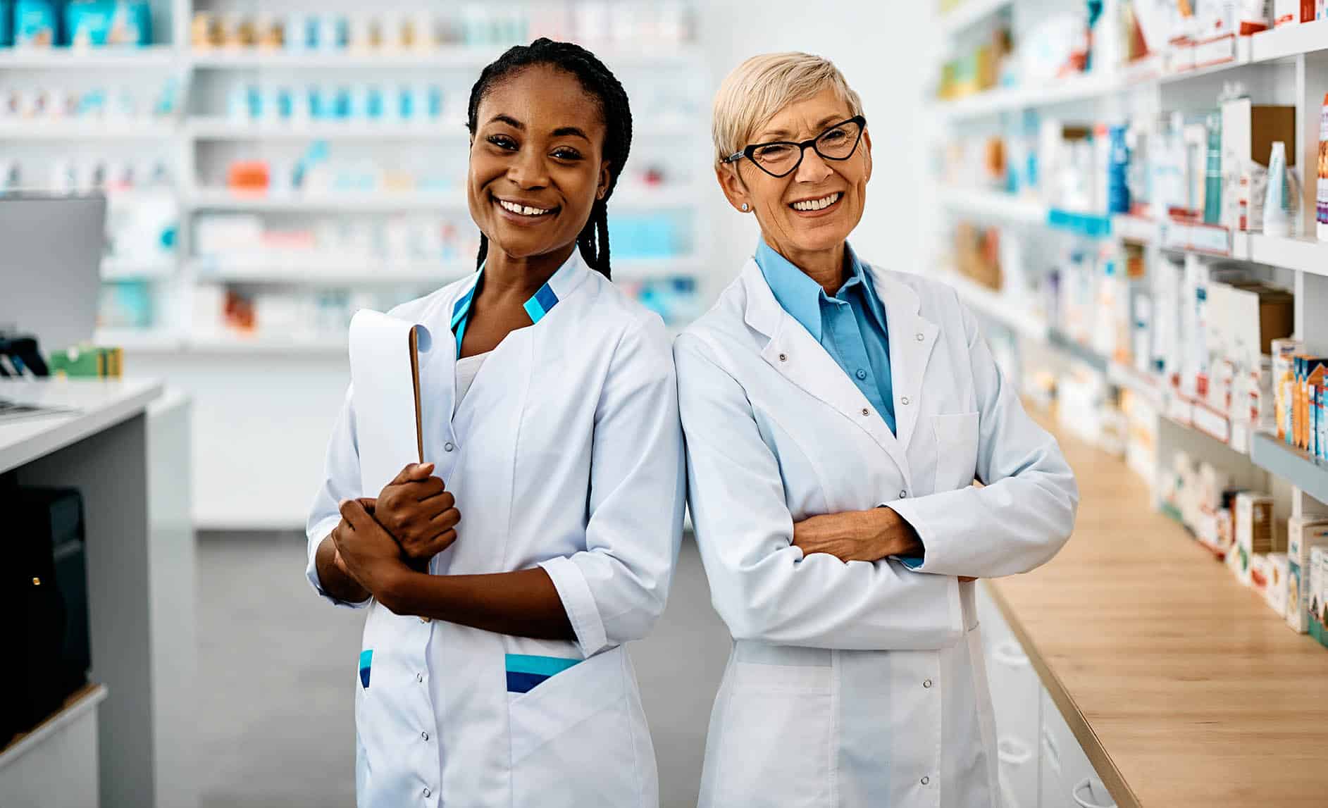 Portrait of happy female pharmacists in pharmacy looking at camera.