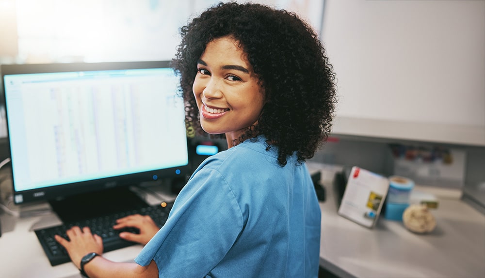 Nurse at hospital on a computer working at her desk